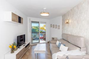 a living room with a couch and a tv at TECAVI III Apartamento in La Pineda
