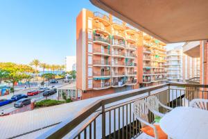 a balcony with a table and chairs and a building at TECAVI III Apartamento in La Pineda