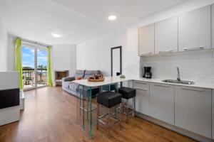 a kitchen and living room with a couch and a table at TECAVI III Apartamento in La Pineda