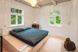 a bedroom with a bed and two windows at Retreat House in Lauvas