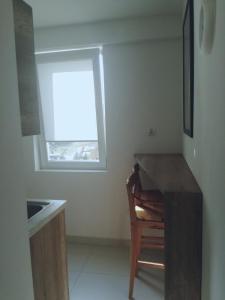 a kitchen with a table and a chair and a window at Apartament Stogi in Gdańsk +2 photos