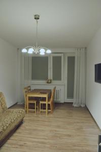 a dining room with a table and chairs and a couch at Apartament Stogi in Gdańsk