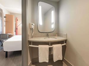a bathroom with a sink and a mirror at ibis Guaiba in Guaíba