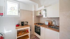 a small kitchen with white cabinets and a sink at Casa Cenzina by Rentbeat in Locorotondo