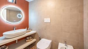 a bathroom with a sink and a toilet and a mirror at Casa Cenzina by Rentbeat in Locorotondo +16 photos