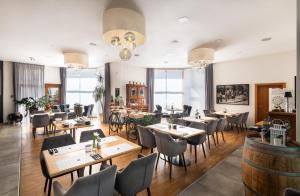 ein Restaurant mit Tischen, Stühlen und Fenstern in der Unterkunft Hotel Troja in Prag