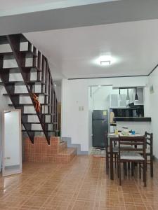 a kitchen and dining room with a staircase in a house at 3G's & C Transient House Calapan in Camilmil