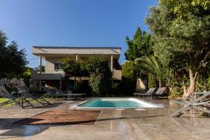 a house with a swimming pool in front of a house at Nataly's Gardens with Pool Lagonissi in Lagonissi