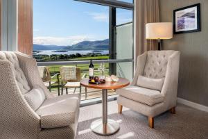 a room with two chairs and a table with a bottle of wine at Aghadoe Heights Hotel & Spa in Killarney