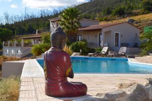 a statue of a woman sitting next to a swimming pool at Quinta O Ninho Bed & Breakfast in Monchique