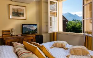 ein Schlafzimmer mit einem Bett und einem Fenster mit Bergblick in der Unterkunft Hotel Le Viscos in Saint-Savin + 13 Fotos