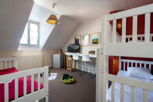 ein Zimmer mit zwei Etagenbetten und einer Küche in der Unterkunft Hotel Le Viscos in Saint-Savin