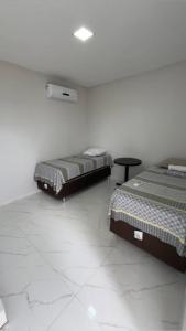 a room with two beds and a table in it at ÁREA do LAZER CIDADE do SOL in Patos