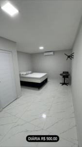 a white room with a bed and a table at ÁREA do LAZER CIDADE do SOL in Patos