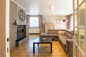 a living room with a couch and a fireplace at Gîte Ô16 in Nassogne