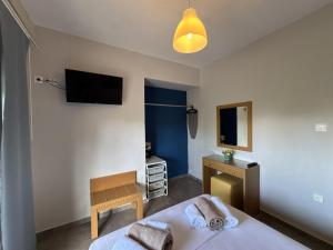a bedroom with two beds and a television on the wall at Makis House in Nikiti