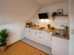 a kitchen with white cabinets and a sink at Jagdhaus am Neubäuer See in Roding