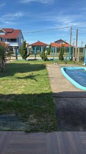 a yard with a swimming pool and a house at Casa com piscina e próxima ao mar em Imbe in Imbé