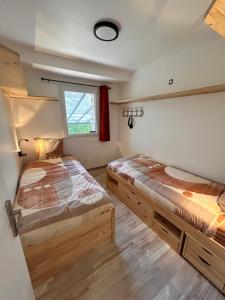 two beds in a room with a window at Gite Les Oliviers d'Ardèche in Chalencon