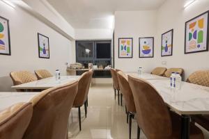 a room with tables and chairs and a kitchen at Treebo Rio Crown Palace in Ahmedabad