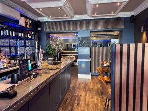 a bar in a restaurant with a counter and chairs at Camelia Hotel in Southend-on-Sea
