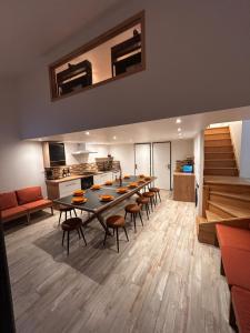 a room with a table and chairs and a kitchen at Gite Les Oliviers d'Ardèche in Chalencon