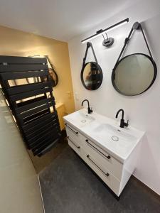 a bathroom with a sink and two mirrors on the wall at Gite Les Oliviers d'Ardèche in Chalencon +22 photos