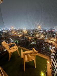 a balcony with two chairs and a view of a city at The Amberwood Escape in Greater Noida