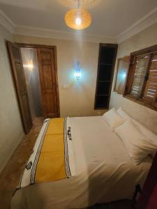 a bedroom with a bed with white sheets and pillows at Dar Imran in Tangier