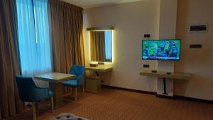 a hotel room with a tv and a table and chairs at Viluxey City Hotel in Maharagama