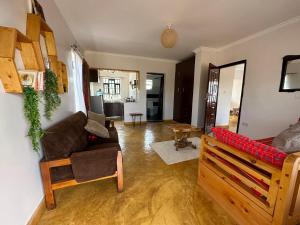a living room with a couch and a chair at Miti Retreat Nanyuki in Naro Moru