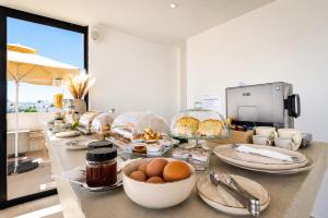 Sandora Living في فاليراكي: بوفيه يحتوي على بيض وأطعمة أخرى على طاولة