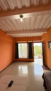 a living room with orange walls and a large window at Jayagiri Inn in Tangkubanperahu