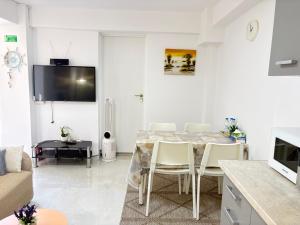 a white living room with a table and chairs at evaxila papaflessa 机场附近 in Glyka Nera