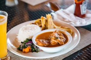 a plate of food with a bowl of soup and bread at Mignon Hotel - Kalule in Kalule