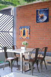 a white table and chairs in front of a brick wall at Mignon Hotel - Kalule in Kalule