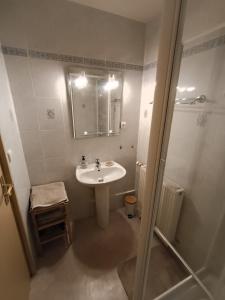 a white bathroom with a sink and a shower at Au cœur de Givet in Givet +18 photos