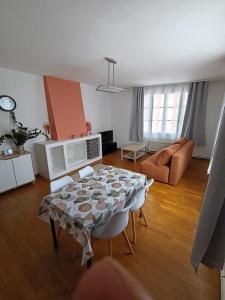 a living room with a table and a couch at Au cœur de Givet in Givet