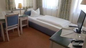ein Hotelzimmer mit Bett und Schreibtisch mit Computer in der Unterkunft Hotel & Gasthof Resengörg in Ebermannstadt