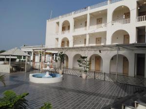 a large white building with a fountain in the courtyard at Ravira Resort in Sītāpur