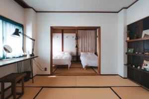 ein Zimmer mit einem Schlafzimmer mit Bett und Schreibtisch in der Unterkunft MOUNTAinn Nagiso in Nagiso
