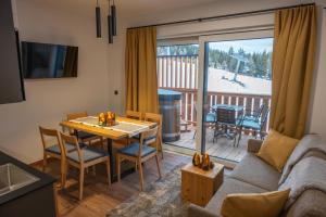 a living room with a couch and a table with chairs at Chaletdorf-Fanningberg in Weisspriach