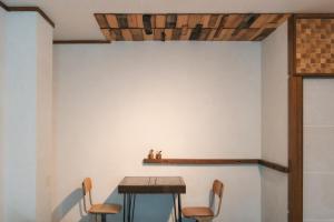 ein Tisch und Stühle in einem Raum mit einer Wand in der Unterkunft MOUNTAinn Nagiso in Nagiso
