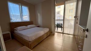 a bedroom with a bed and a balcony at EG Beach Apartments 105A in Lezhë