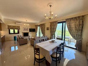 a dining room and living room with a table and chairs at Thomas Apartments in Dassia