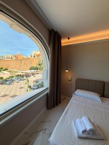 a bedroom with a large window and a bed with towels on it at Hotel Santa Lucia in Termoli +279 photos