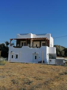 a white house sitting in the middle of a field at Countryside Retreat 1 in Agios Arsenios