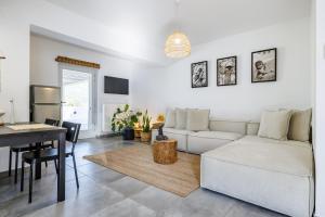 a living room with a white couch and a table at Casa Naturale in Skopelos Town