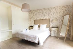 sypialnia z białym łóżkiem i lustrem w obiekcie Natura Petit Hotel w mieście Revolta