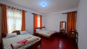 a bedroom with two beds and a mirror at Kataragama Brain Hotel in Kataragama